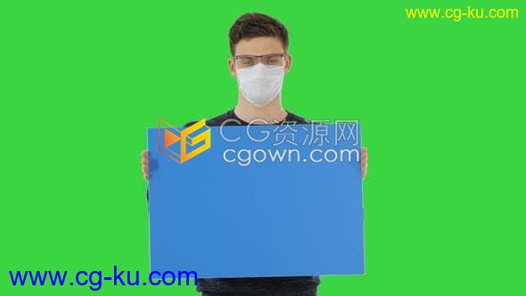 年轻人带着医用口罩举着标语牌使用绿色屏幕背景实拍视频素材下载的图片1